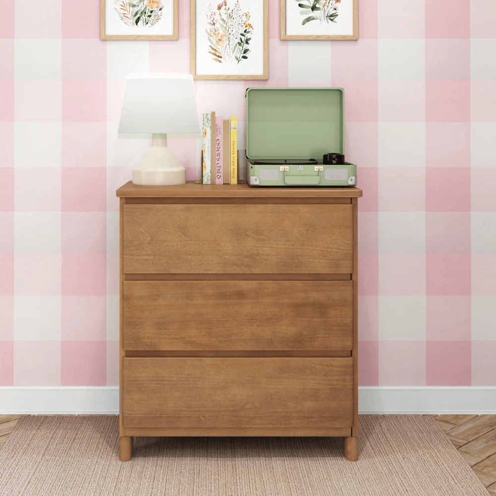 Max & Lily Modern Farmhouse 3 Drawer Dresser in Pecan - front view in a kids bedroom with a lamp, books and record player styled on top