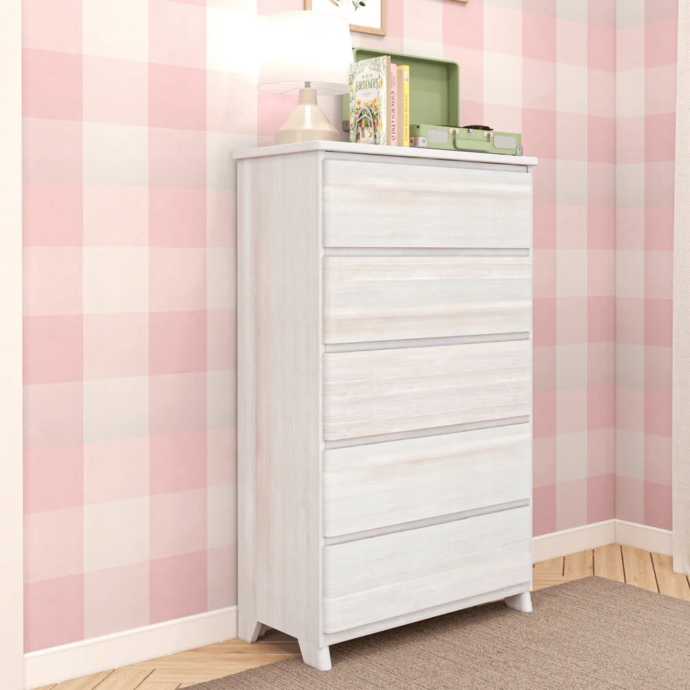 Max & Lily Modern Farmhouse 5 Drawer Dresser in White Wash - angled view in a corner bedroom setting with decor on top