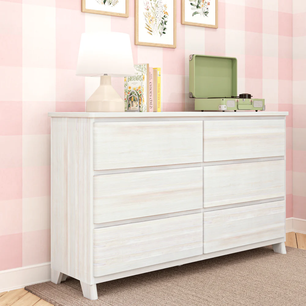 Max & Lily Modern Farmhouse 6 Drawer Dresser in White Wash - angled view in a pink plaid room with decor styled on top