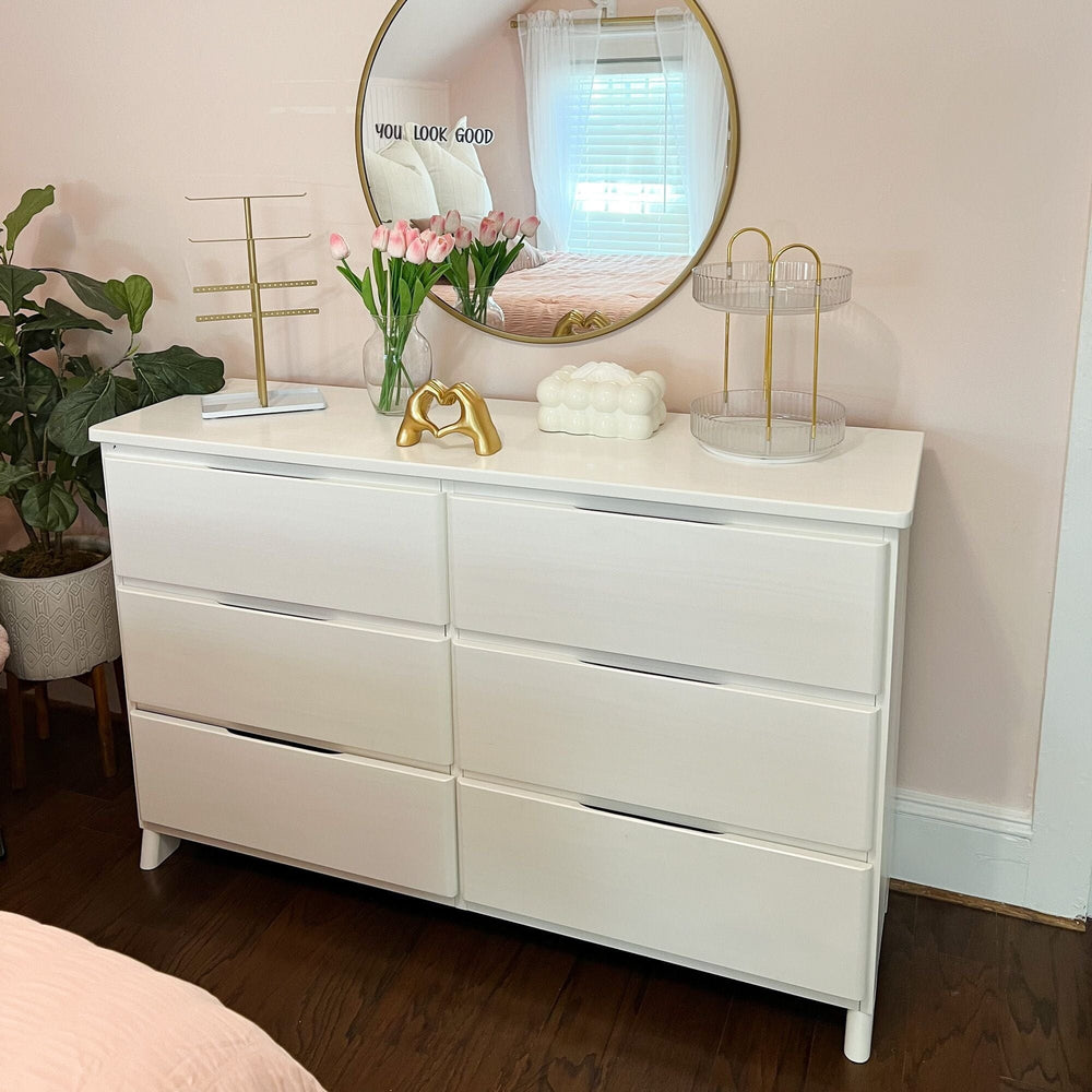 Max & Lily Modern Farmhouse 6 Drawer Dresser in White Wash - styled in a bedroom with a round mirror, tulips, and plants