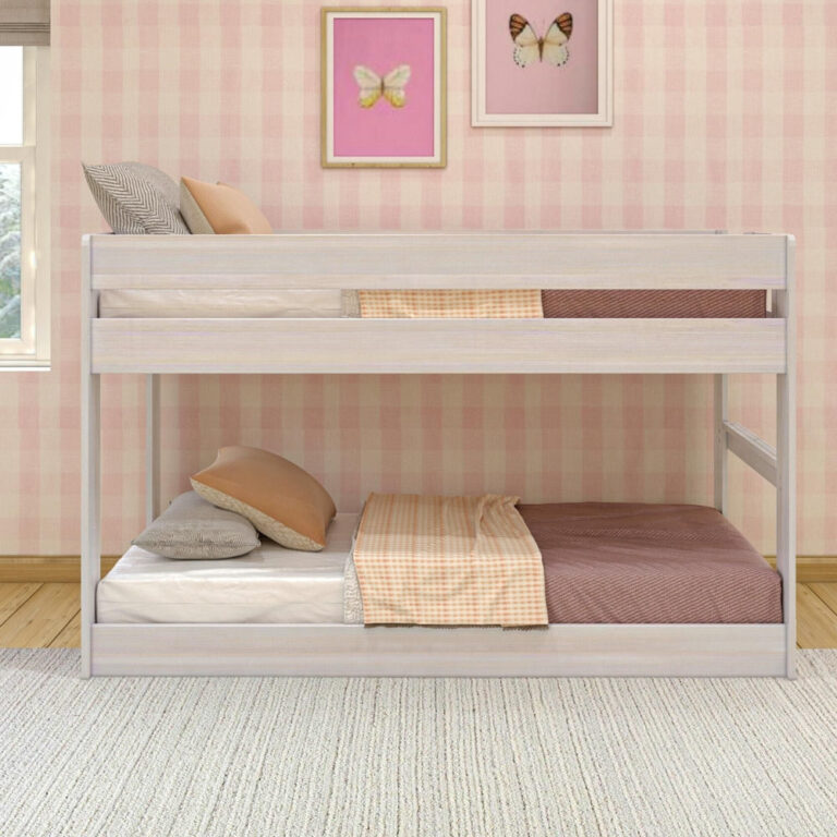 Max & Lily Modern Farmhouse Twin Over Twin Low Bunk Bed in White Wash - front view styled with pillows and bedding against a pink bedroom wall