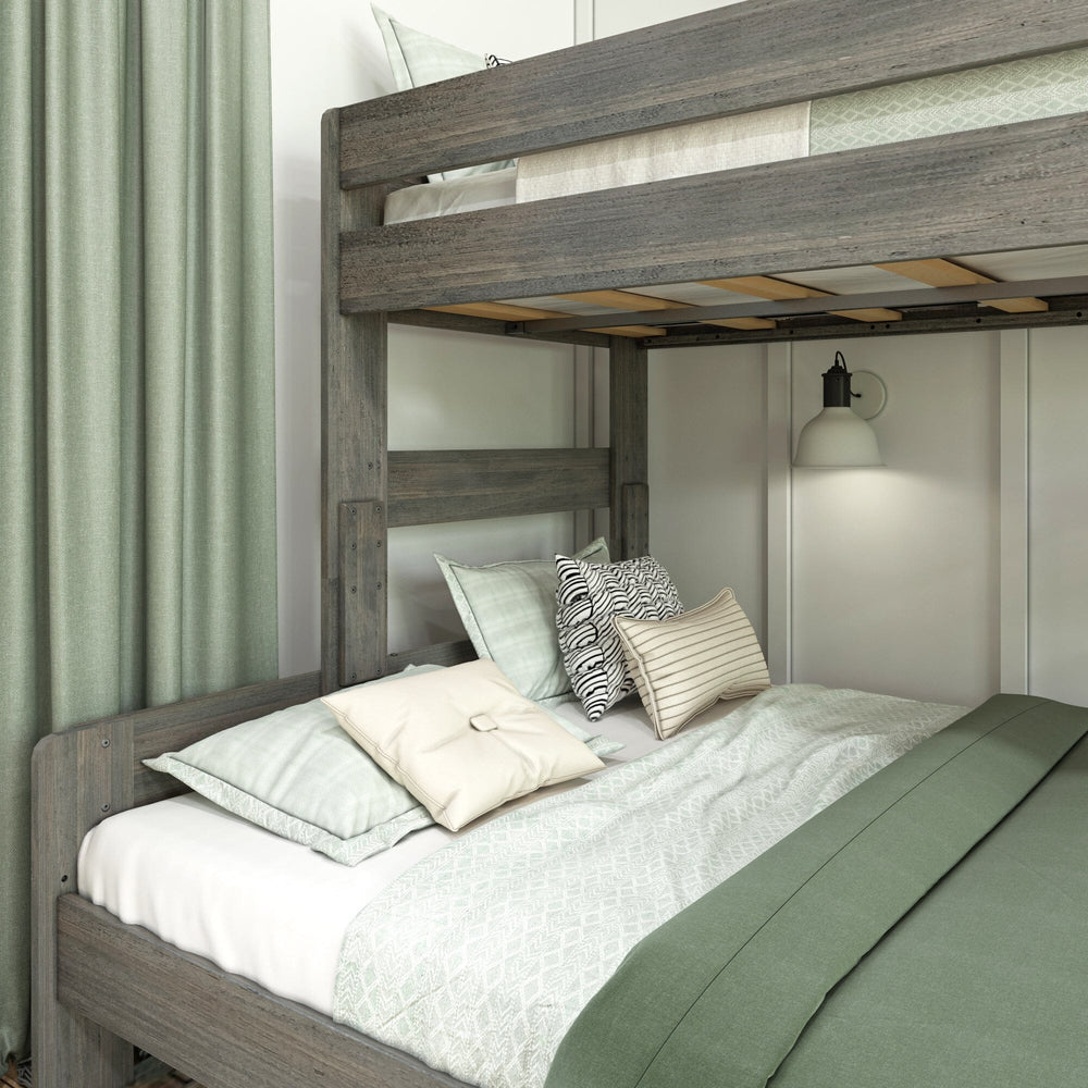 Max & Lily Modern Farmhouse Twin XL-Over-Queen Bunk Bed in Driftwood - close-up of the lower queen bunk styled with pillows, showing the wooden slats beneath the top bunk.