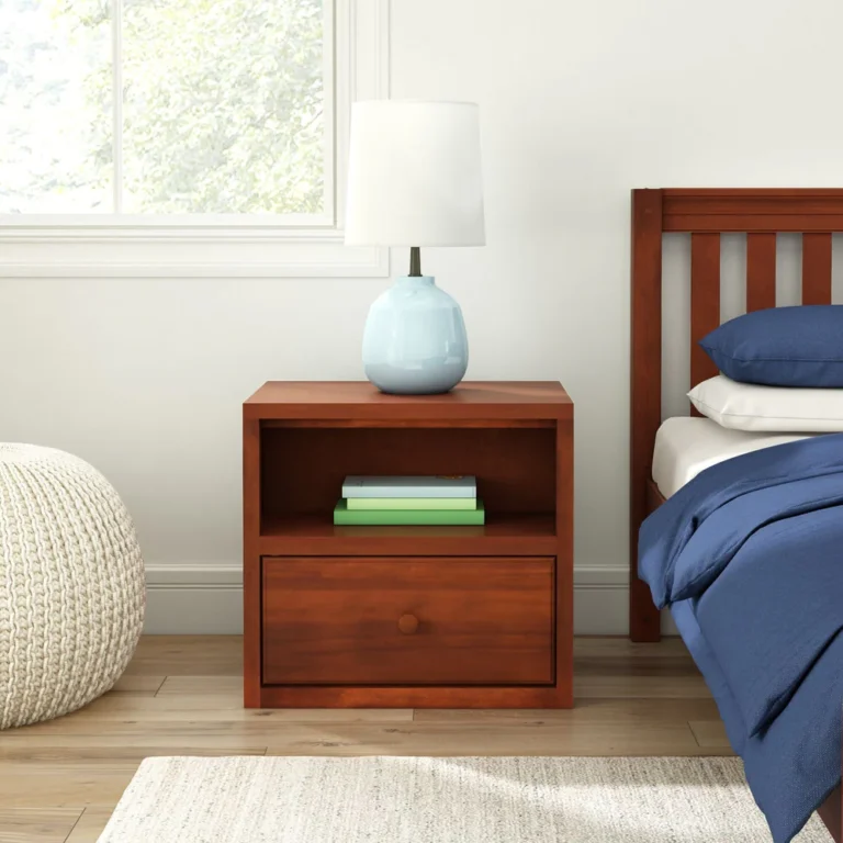 Maxtrix 1 Drawer Nightstand in Chestnut - front view in a bedroom setting next to a bed, with a lamp on top and books tucked in the open shelf