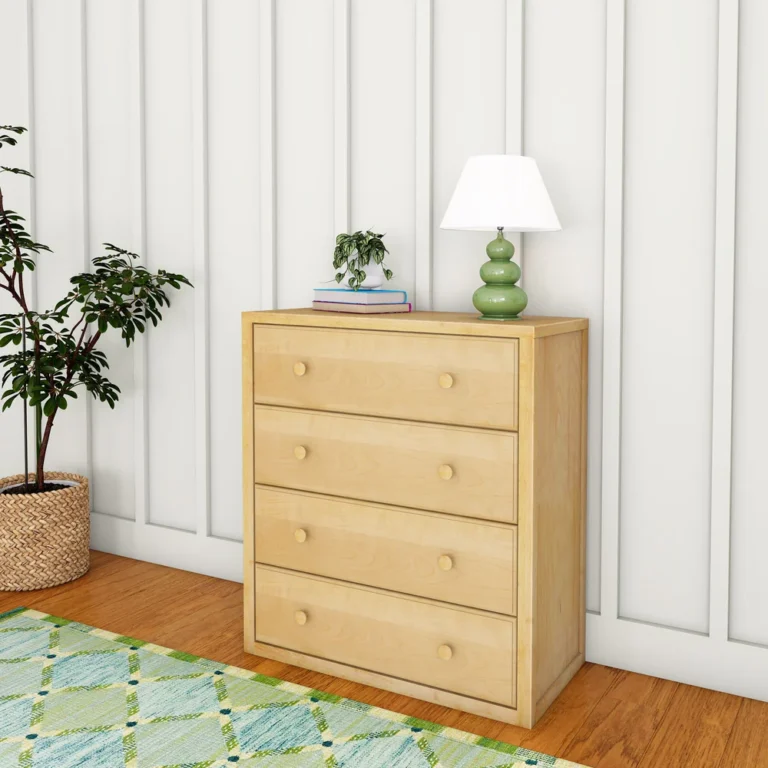 Maxtrix 4 Drawer Dresser Natural Room Scene Maxtrix 4 Drawer Dresser in Natural - angled view in a bedroom beside a potted plant, styled with a lamp and books on top