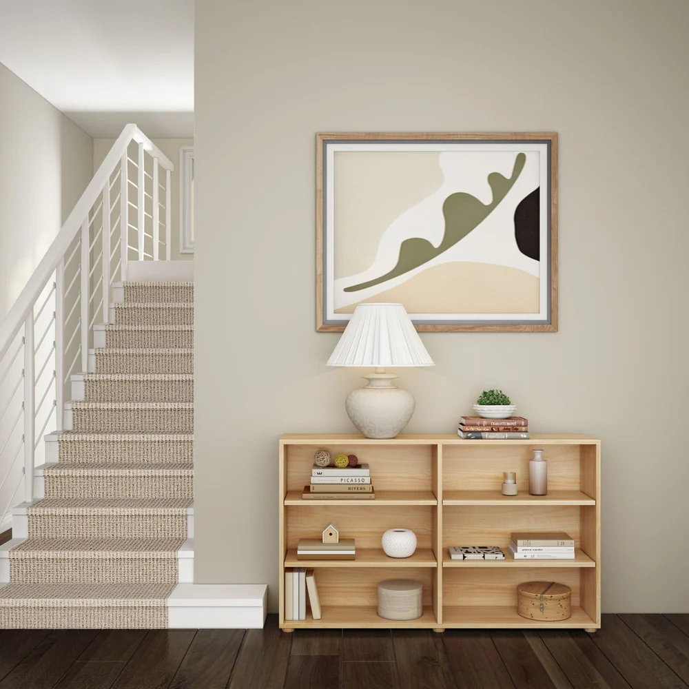 Maxtrix 6 Shelf Bookcase in Natural - room scene at the foot of a staircase, the bookcase styled with books, a table lamp and baskets