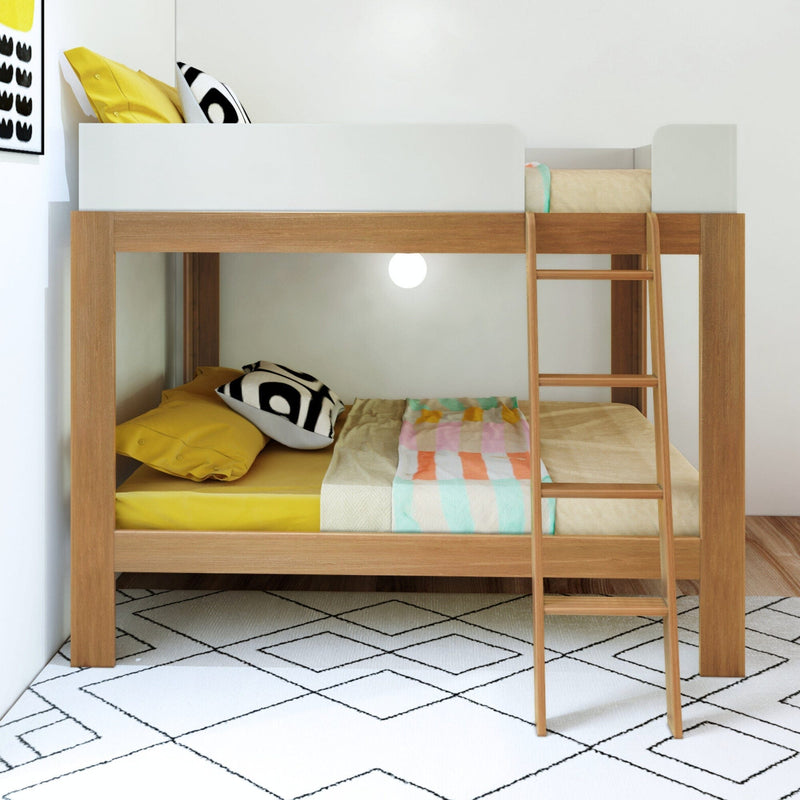 Mid-Century Modern Full Over Full Bunk Bed in White/Pecan - front view of the lower bunk made with bedding beside the angled ladder.