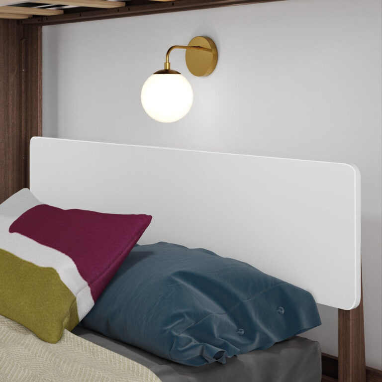 Mid-Century Modern Twin Over Full L-Shaped Bunk Bed in White/Walnut - close-up of the lower bed's white headboard panel with pillows beneath a brass wall sconce