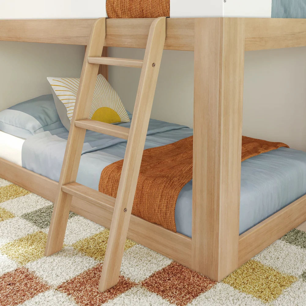 Mid-Century Modern Twin Over Twin Low Bunk Bed in White/Blonde - closeup of the angled ladder rungs beside the made-up lower bunk