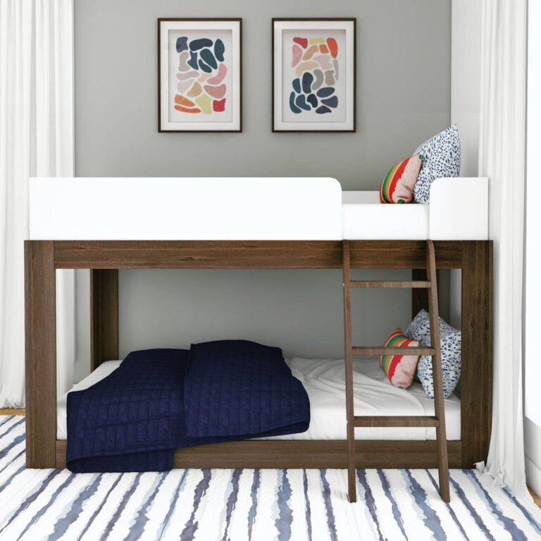 Mid-Century Modern Twin Over Twin Low Bunk Bed in White/Walnut - front view in a kids' room with navy bedding and the angled ladder hooked onto the top bunk
